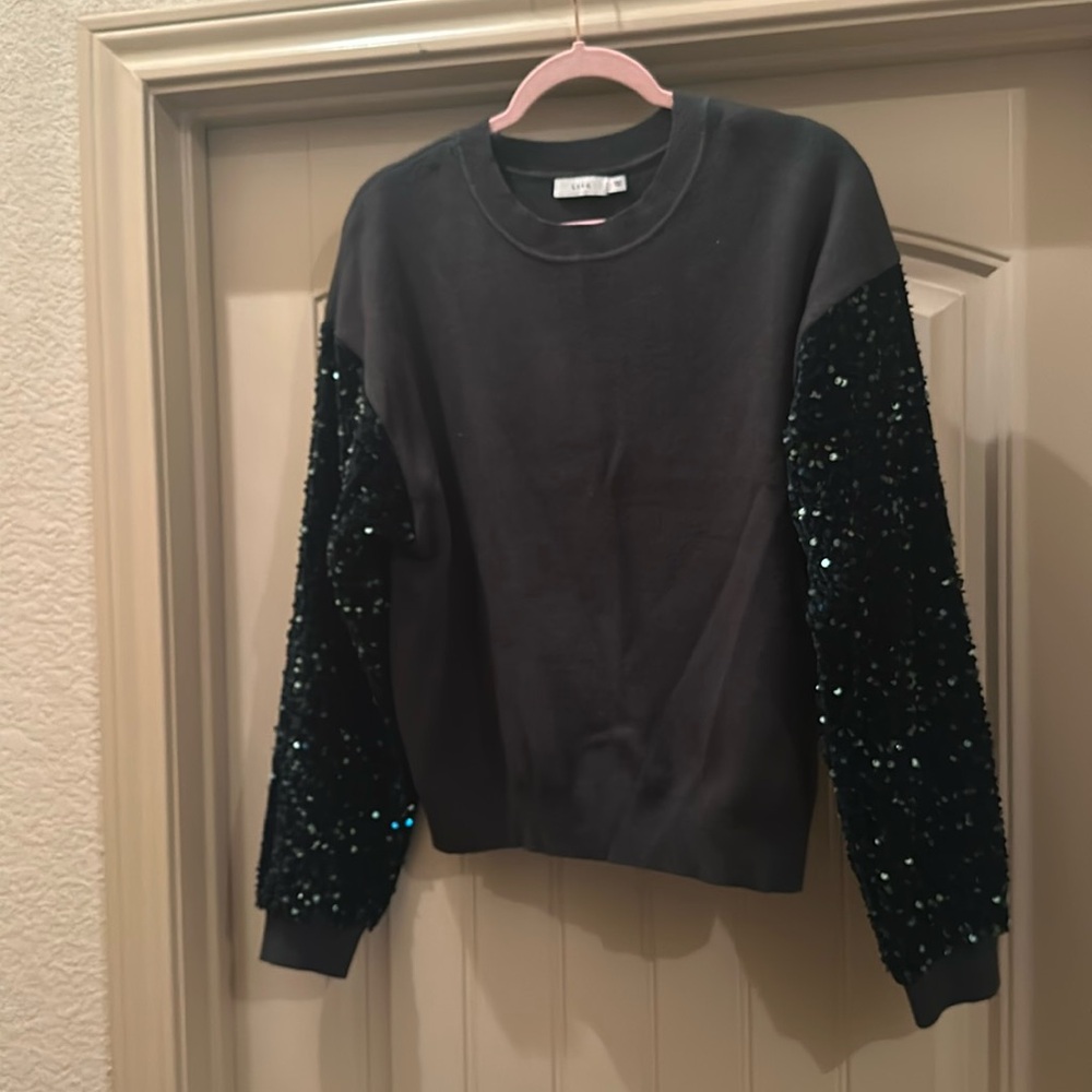 Green sweater with sequin sleeves.